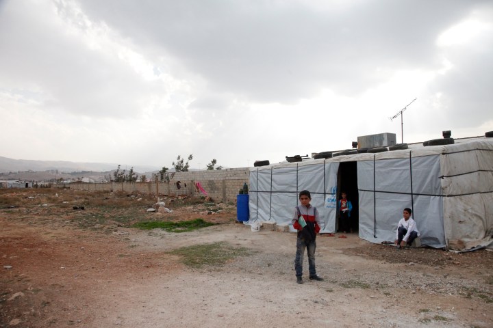 Syrian children outside their temporary home, in Lebanon's Bekaa Valley