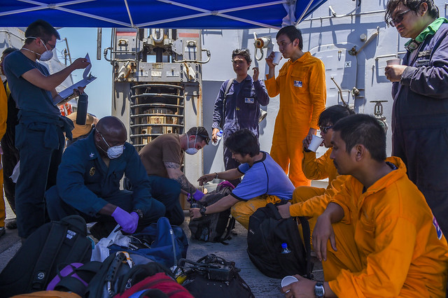 Sailors aboard USS Bainbridge (DDG 96) render aid to the crew of